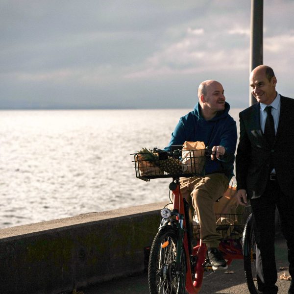 Philosoph auf seinem Fahrrad und Bestatter spazieren am Meer entlang
