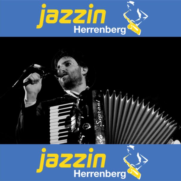 Daniel Kahn mit Akkordeon und Jazzin-Bannern